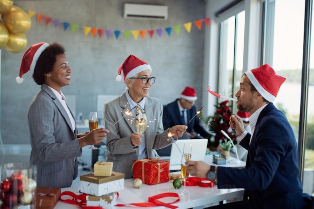 Colegas de negocios juguetones divirtiéndose en la fiesta de Navidad en la oficina