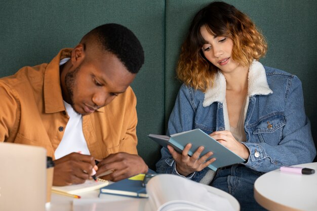 Colegas que estudian desde cuadernos durante la sesión de estudio