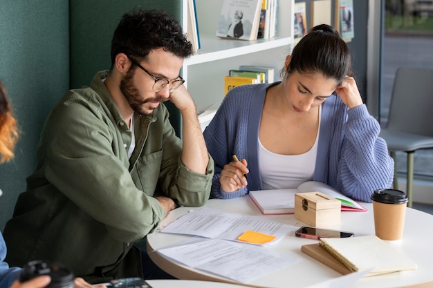 Foto gratuita colegas que estudian desde cuadernos durante la sesión de estudio