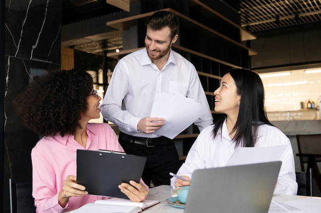 Colegas que trabajan juntos usando una computadora portátil y documentos