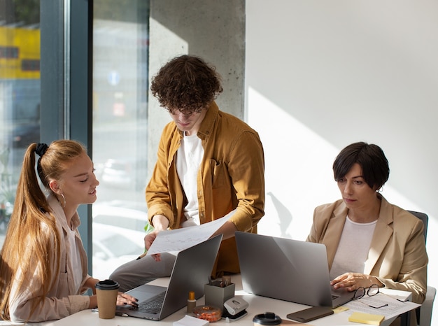 Foto gratuita colegas que trabajan en la oficina plano medio