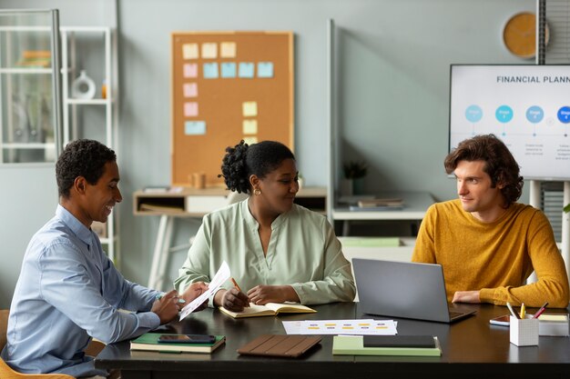 Colegas que trabajan en la oficina plano medio