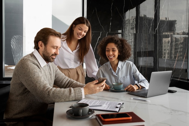 Colegas sonrientes de tiro medio en el trabajo