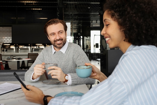 Foto gratuita colegas sonrientes en el trabajo durante el tiempo de descanso plano medio