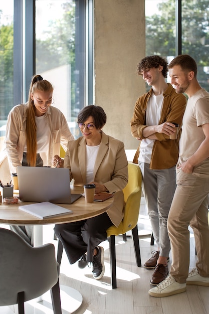 Foto gratuita colegas de tiro completo trabajando en una oficina acogedora