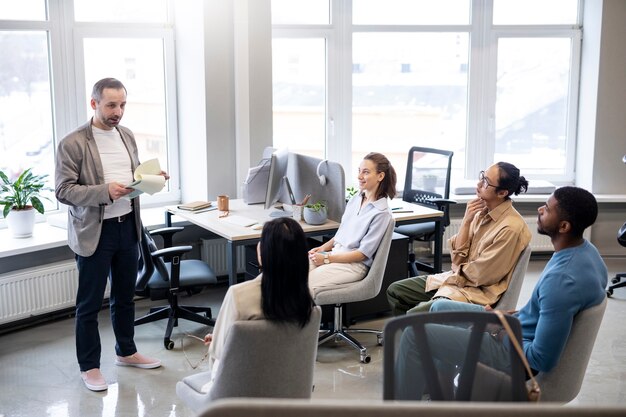 Colegas de tiro medio aprendiendo en el trabajo