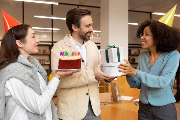 Colegas de tiro medio celebrando cumpleaños.