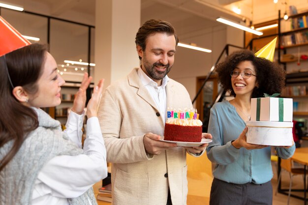 Colegas de tiro medio celebrando con pastel