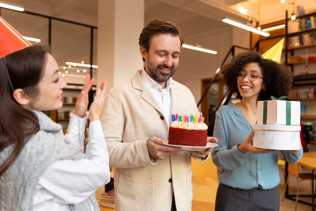 Colegas de tiro medio celebrando con pastel