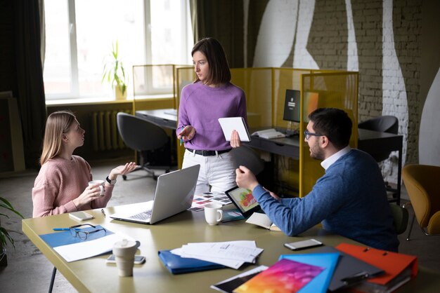 Colegas de tiro medio debatiendo ideas en el trabajo