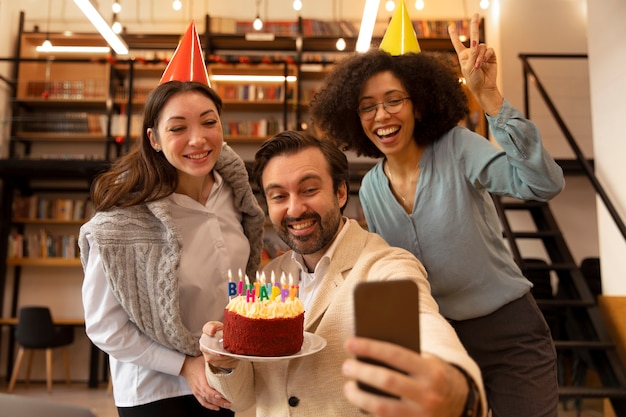 Colegas de tiro medio tomando selfie con teléfono