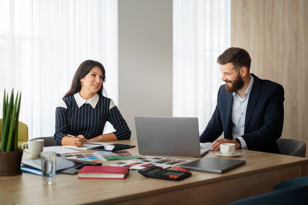 Colegas de tiro medio trabajando en el escritorio