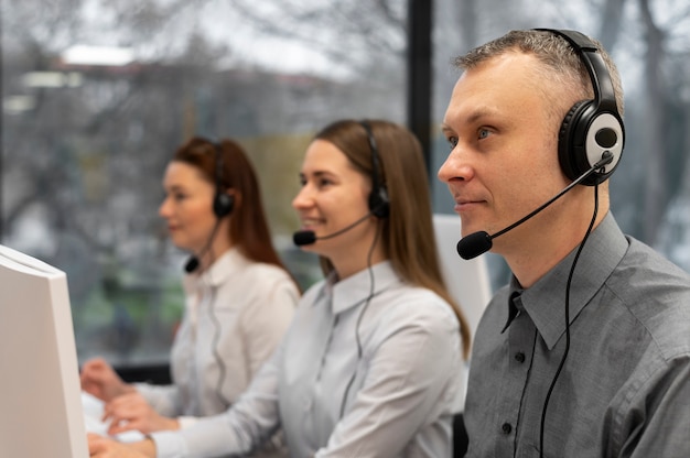 Colegas trabajando juntos en un centro de llamadas con auriculares