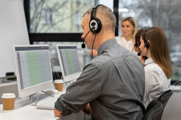 Colegas trabajando juntos en un centro de llamadas con auriculares