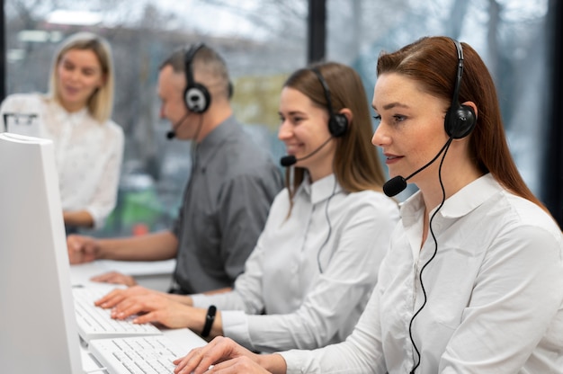 Colegas trabajando juntos en un centro de llamadas con auriculares