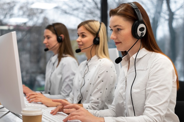 Colegas trabajando juntos en un centro de llamadas con auriculares