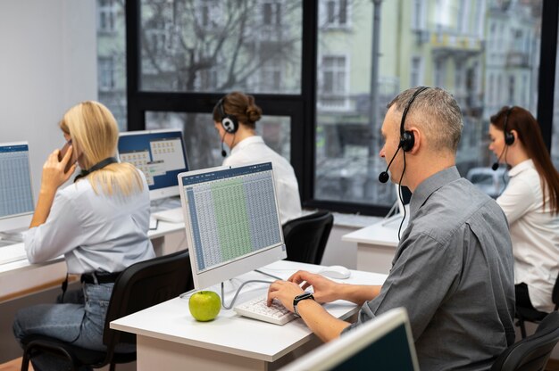 Colegas trabajando juntos en un centro de llamadas con auriculares