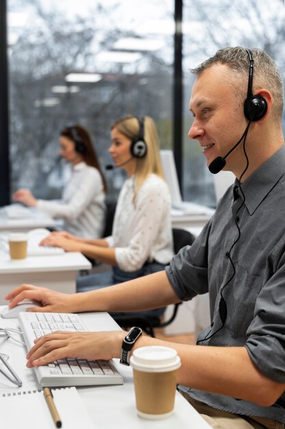 Colegas trabajando juntos en una oficina de call center con café