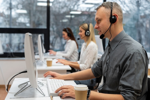 Colegas trabajando juntos en una oficina de call center con café