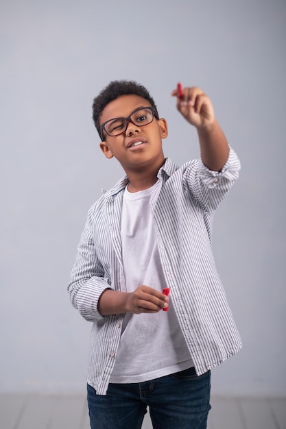 Foto gratuita colegial afroamericano concentrado que hace un bosquejo