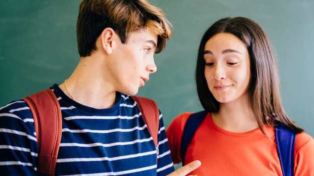 Colegial diciendo algo a su amiga