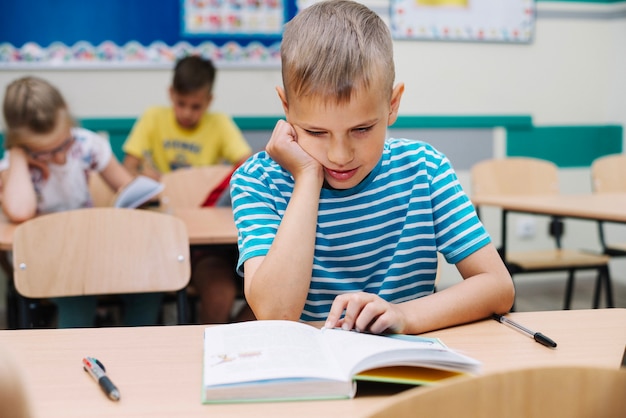 Colegial, sentado, tabla, lectura, libro de texto