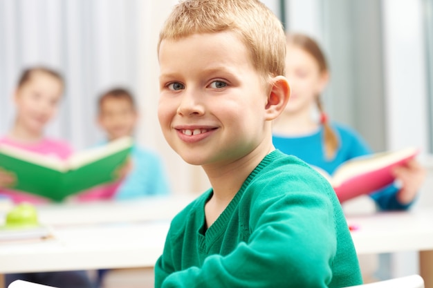 Colegial sonriente con suéter verde