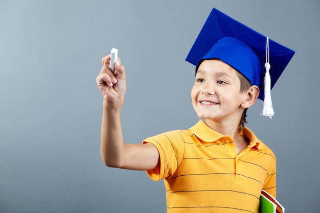 Foto gratuita colegial sonriente sujetando una tiza