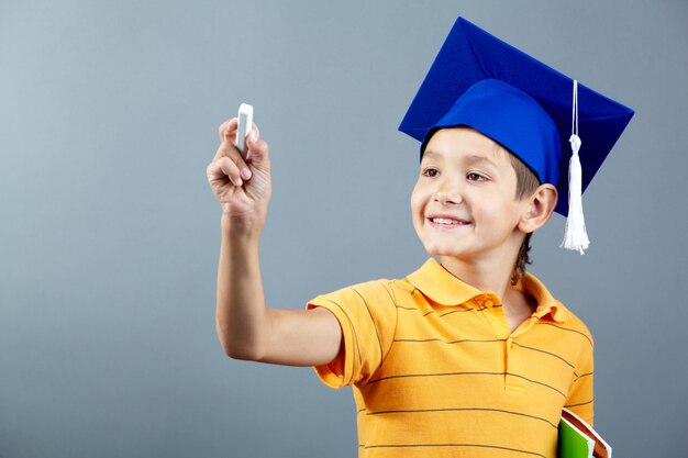 Colegial sonriente sujetando una tiza