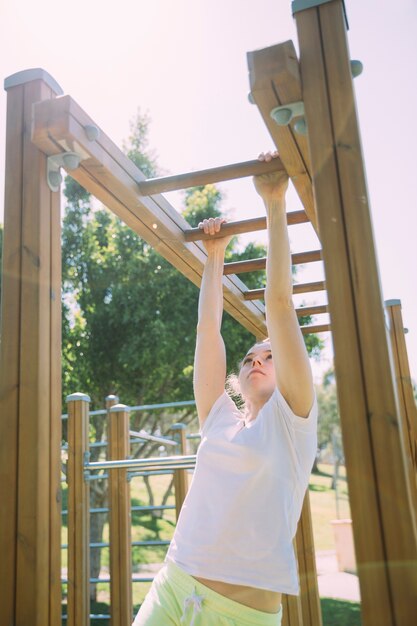 Colegiala adolescente escalando en el gimnasio de la selva