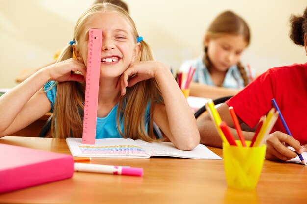 Colegiala alegre jugando con la regla