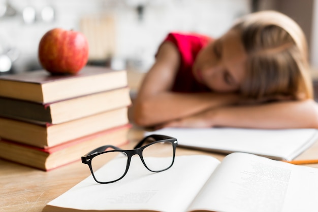 Colegiala cansada que duerme en el escritorio