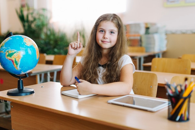 Foto gratuita colegiala en clase apuntando hacia arriba