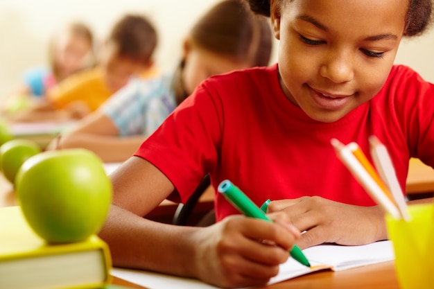 Colegiala concentrada con su lápiz verde