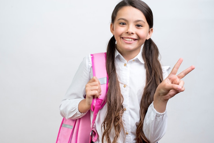 Foto gratuito colegiala hispana juguetona llevando mochila en el hombro.