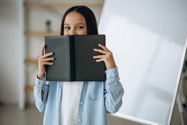 Foto gratuita colegiala con libro en casa