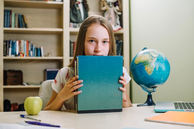 Foto gratuita colegiala con libros en la mesa