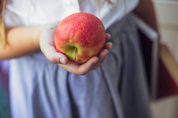 Colegiala con manzana en mano