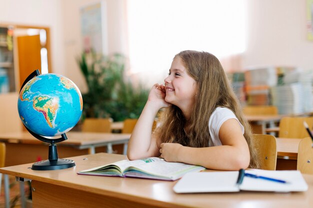 Colegiala, sonriente, escritorio