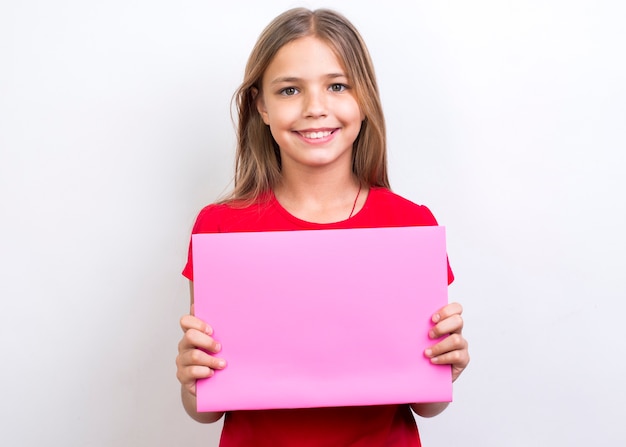 Colegiala sonriente mostrando un cuaderno vacío