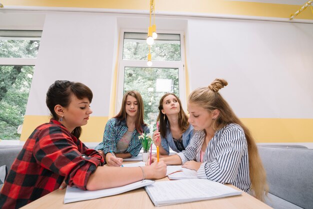 Colegialas colaborando en estudios