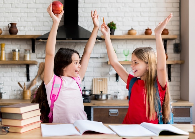 Foto gratuita colegialas con las manos arriba mirándose