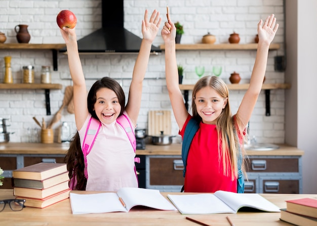 Colegialas con las manos de pie en la cocina