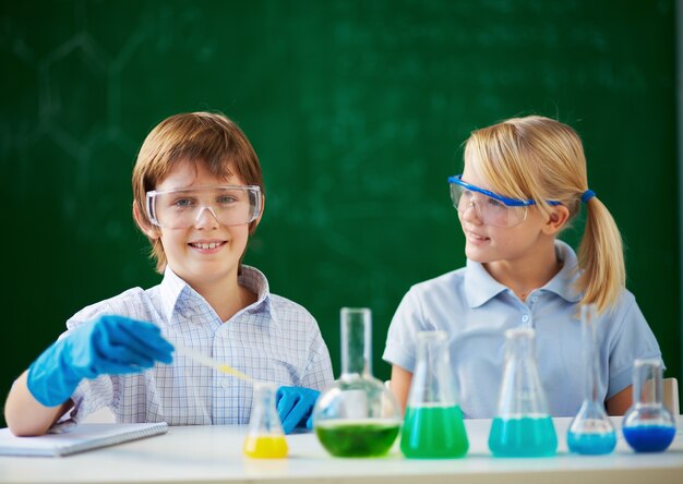 Colegiales protegiéndose los ojos en el laboratorio