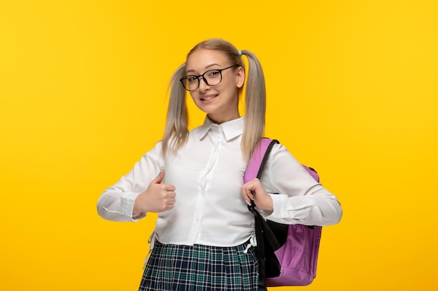 Coletas de colegiala joven rubia del día mundial del libro con mochila rosa