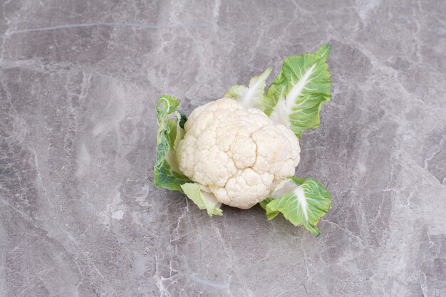 Coliflor blanca aislada sobre superficie de mármol gris