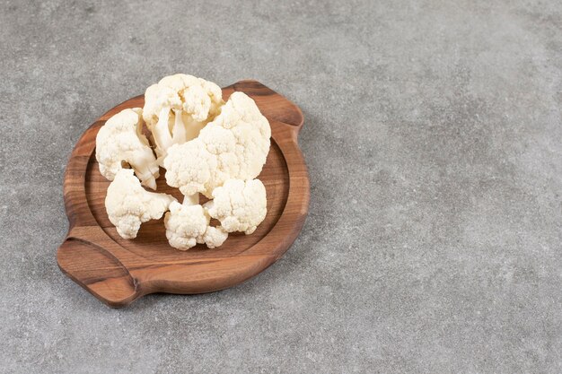 Coliflor blanca madura fresca colocada sobre tabla de madera.