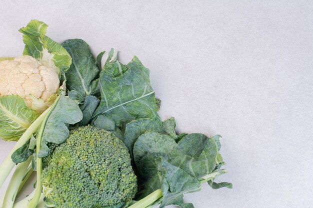 Coliflor y brócoli en mesa blanca.