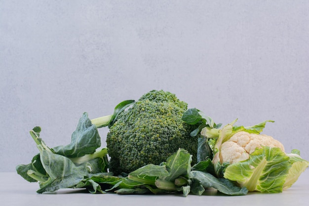 Coliflor y brócoli en mesa blanca.