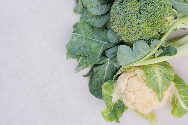 Coliflor y brócoli sobre superficie blanca